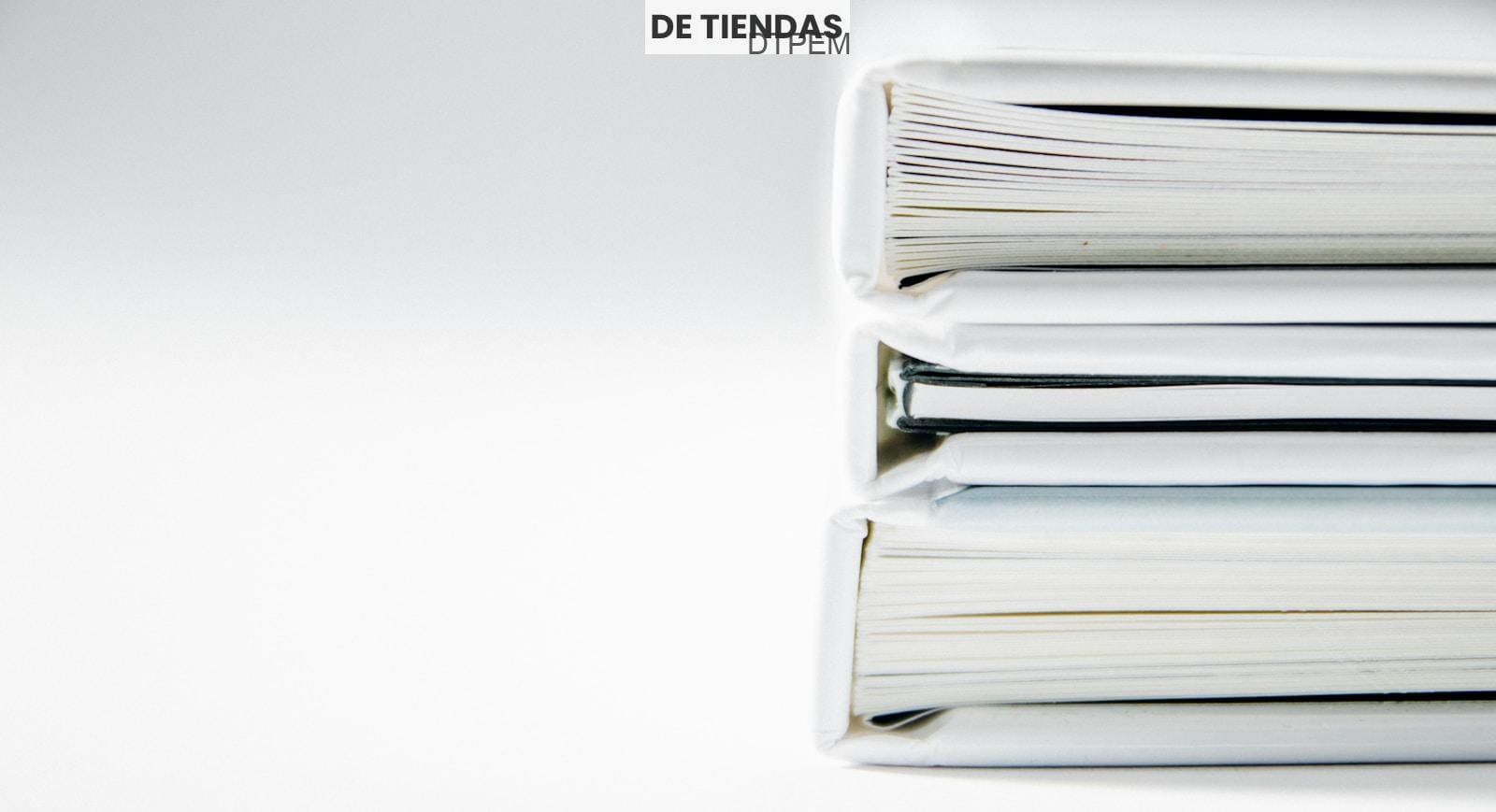 A stack of thick folders on a white surface